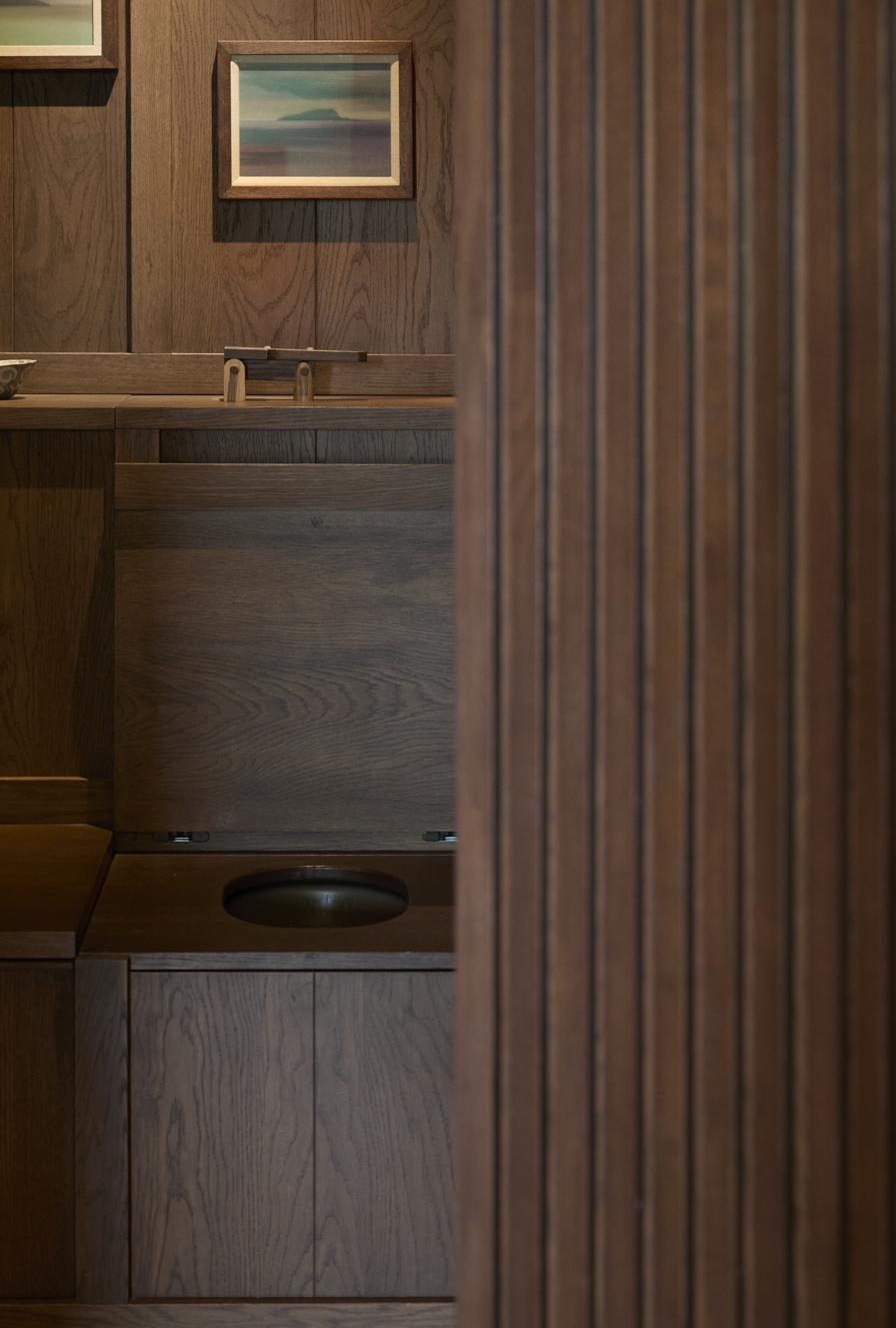 Powder room vanity with round bronze basin, private residence